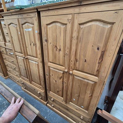 Lot 148 - A pair of pine two-door wardrobes.