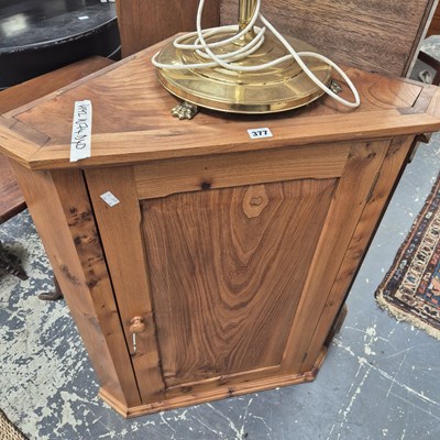 Lot 377 - An elm corner cabinet and a brass lamp