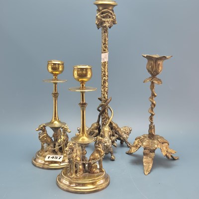 Lot 1457 - A pair of brass candlesticks, each supported...