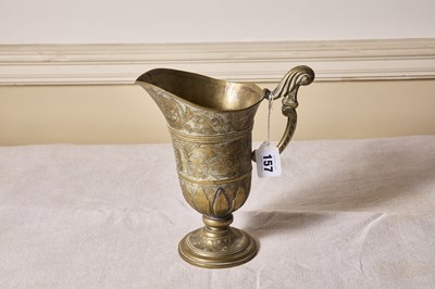 Lot 157 - An early brass helemt form jug, overal etched...