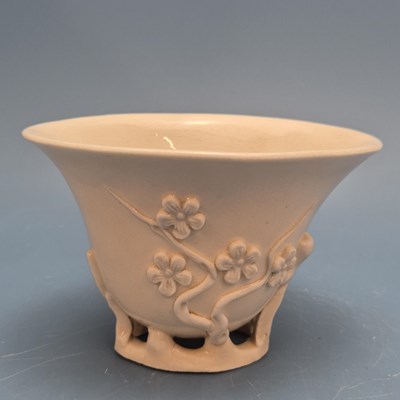 Lot 1631 - A blanc de Chine libation cup, the branches of...