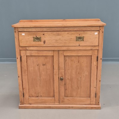 Lot 1655 - A pine side cabinet with a long drawer over...
