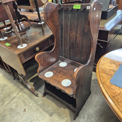 Lot 85 - An antique oak lambing chair with plank wing...