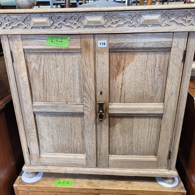 Lot 116 - A bleached oak small side cabinet with panel...