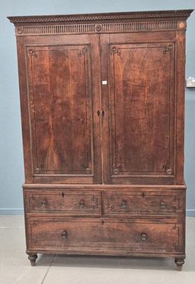 Lot 323 - A late Georgian inlaid oak linen press, dentil...