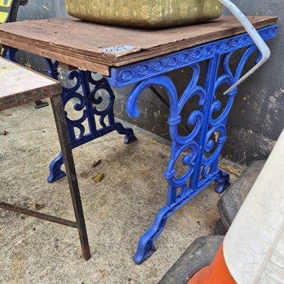 Lot 421 - A small garden table with cast ends.