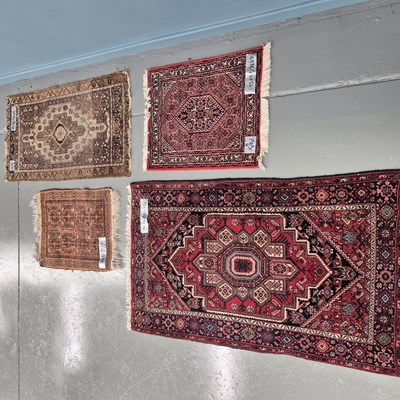 Lot 908 - A group of four small Oriental rugs, two...
