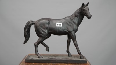 Lot 606 - A black composition model of a horse walking...