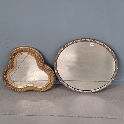 Lot 654 - A circular mirror in a silvered frame painted...