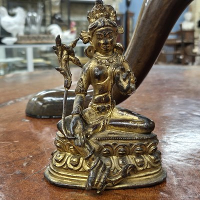 Lot 679 - An eastern gilded bronze figure of a seated...