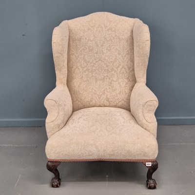 Lot 684 - A Georigan style wingback armchair on carved...