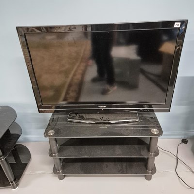 Lot 736 - A Toshiba flat screen TV with glass stand