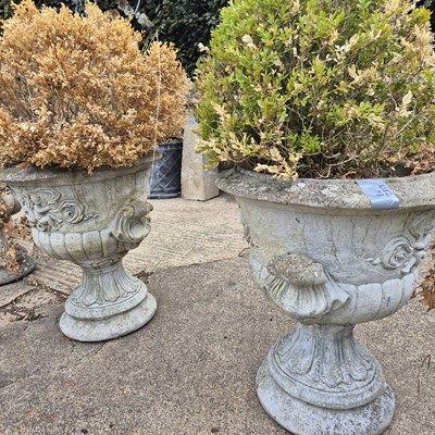 Lot 1082 - A set of three classical-style garden urns,...