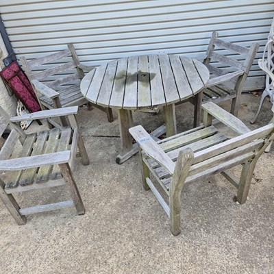 Lot 1103 - A weathered teak patio table and four matching...