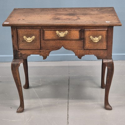 Lot 1395 - A late Georgian country oak lowboy with three...