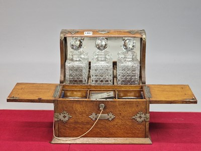 Lot 1407 - A Victorian oak three-bottle tantalus with...