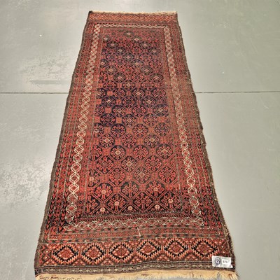Lot 573 - An antique Belouch runner, retaining flat...