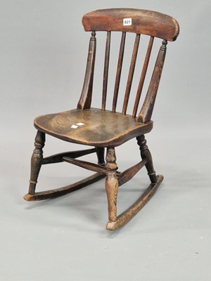 Lot 821 - A child's oak rocking chair with a broad top...
