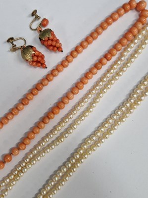 Lot 1227 - A row of graduated coral coloured beads with a...