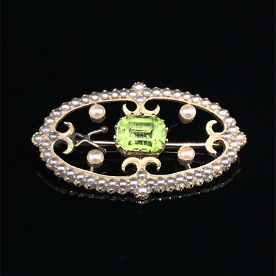 Lot 1234 - An antique peridot and seed pearl oval brooch,...