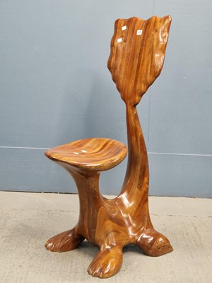 Lot 320 - A modern teak chair carved from fused sheets...