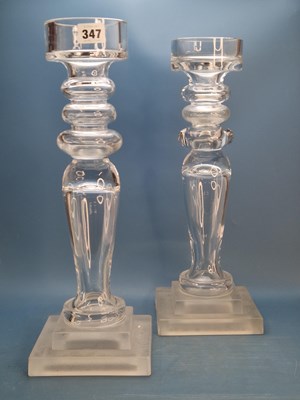 Lot 347 - A pair of clear glass candle holders supported...