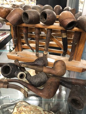 Lot 283 - A rack of briar pipes, others loose, military...