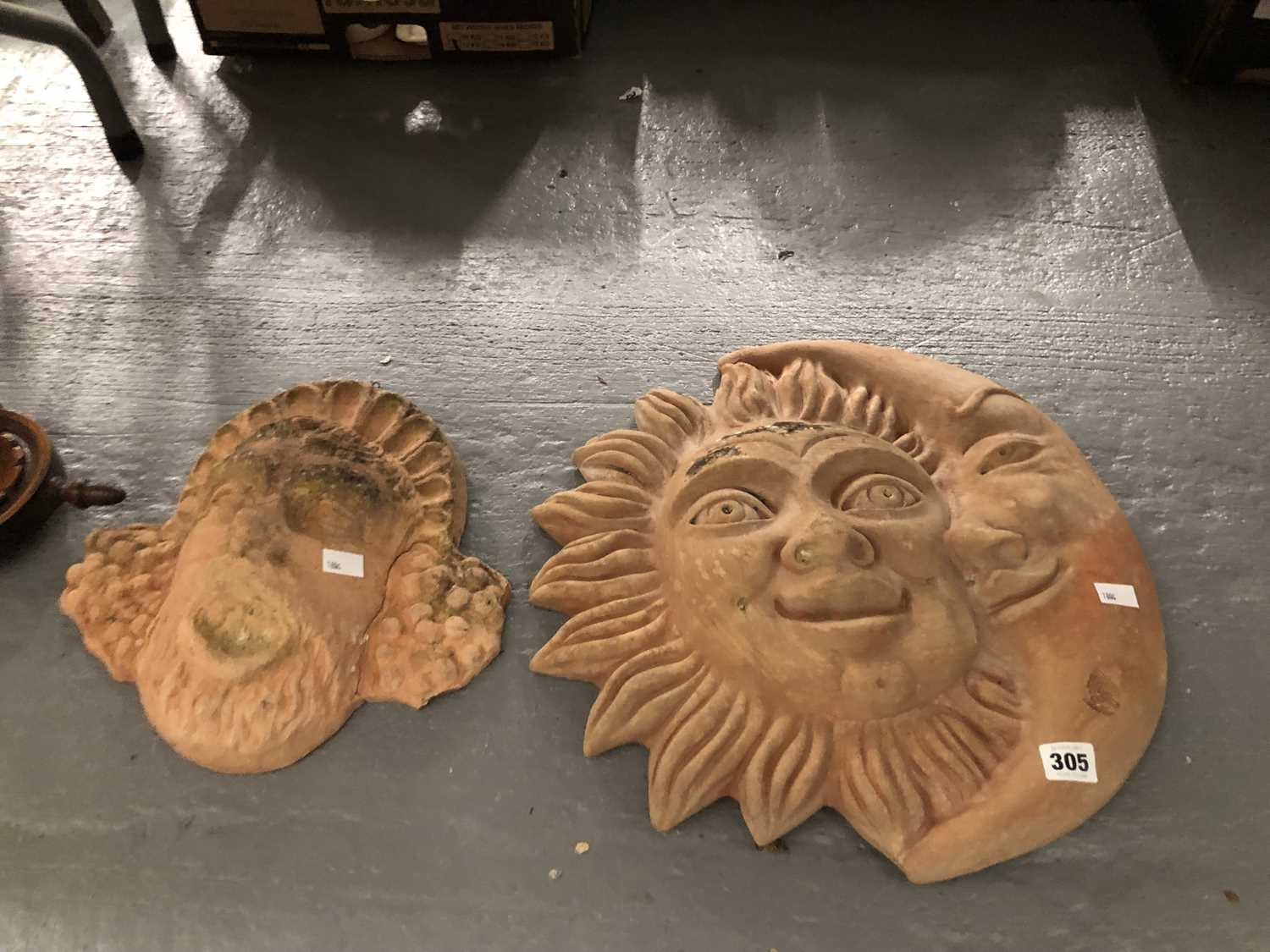 Lot 305 - A terracotta sun and moon wall plaque together...