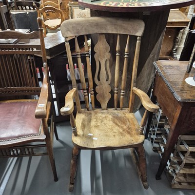 Lot 820 - An antique kitchen spindle back rocking chair.