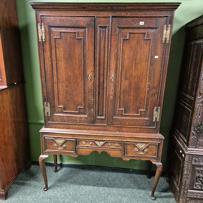 Lot 668 - An 18th century panel door cabinet on three...
