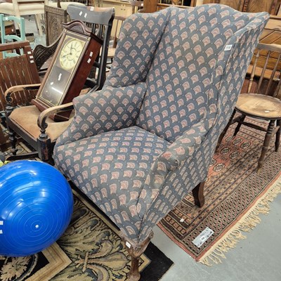 Lot 719 - A large wing back armchair.