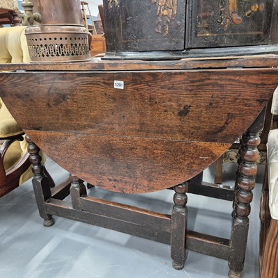 Lot 1201 - An 18th century oak country drop leaf gateleg...