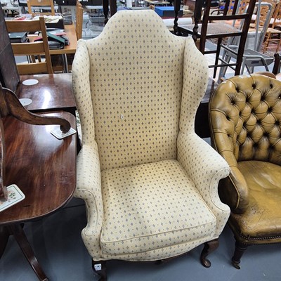 Lot 1143 - A queen anne style wing back armchair.