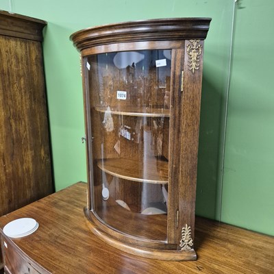 Lot 1074 - A small bow front corner cabinet