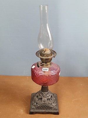 Lot 532 - A late Victorian oil lamp with a cranberry...
