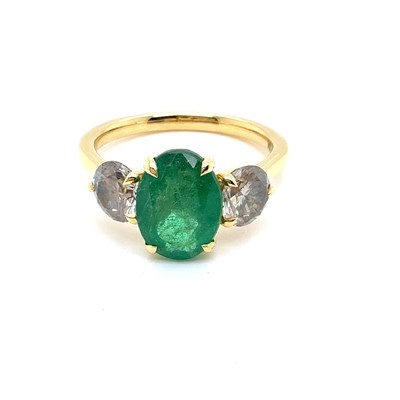 Lot 23 - An oval emerald and round brilliant cut...
