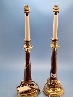 Lot 229 - A pair of gilt bronze and red marble table lamps