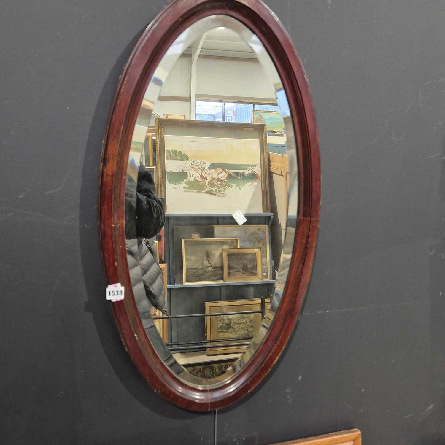 Lot 1538 - an oval wall mirror.