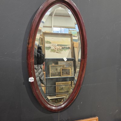 Lot 1538 - an oval wall mirror.
