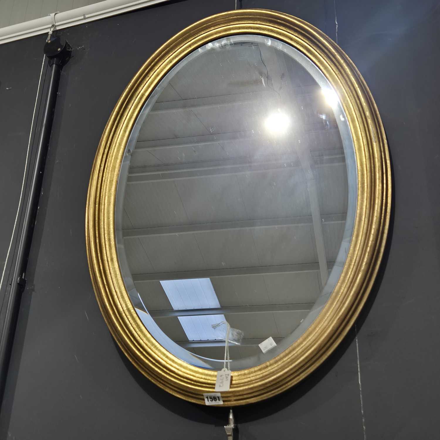 Lot 1561 - A large oval gilt framed wall mirror.