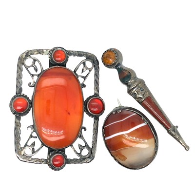 Lot 1031 - A large brooch set with an oval orange...