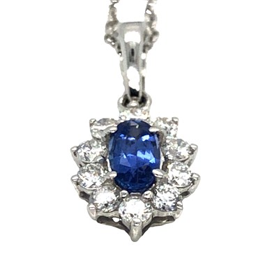 Lot 1052 - An 18ct white gold oval sapphire and round...