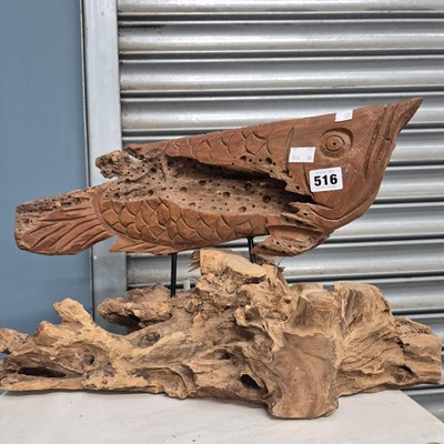 Lot 516 - A drift wood fish carving raised on a rustic...