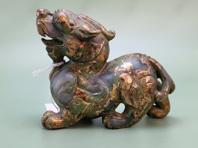 Lot 1211 - A Chinese parcel gilt green stone qilin.   W...
