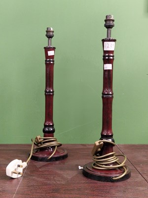 Lot 1239 - A pair of wine red patinated  metal column...