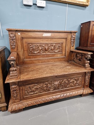 Lot 66 - A Victorian carved oak hall settle with box seat.