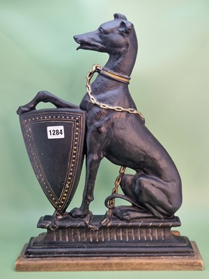 Lot 1284 - A cast iron door stop in the form of a seated...