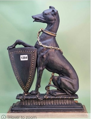 Lot 1284 - A cast iron door stop in the form of a seated...