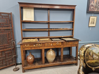 Lot 1377 - An 18th century oak dresser with an open three...