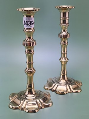 Lot 1439 - A pair of late 18th century brass petal base...